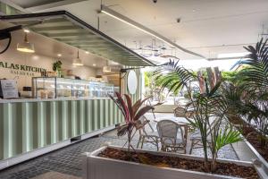 Beachside Palm Beach Luxury - 2 Bedroom Apartment في غولد كوست: مطعم بالنباتات والطاولات والكراسي