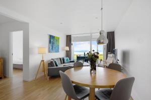 a living room with a table and a couch at Beautiful Holiday Apartment With A View Of Ebeltoft Vig And Walking Distance To The Town Center in Ebeltoft