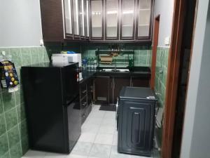 a kitchen with a black refrigerator and a trash can at Amara Homestay Cameron Highlands in Cameron Highlands
