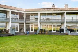 a large building with a lawn in front of it at Beautiful Apartment In The First Row With A View Of Ebeltoft Vig in Ebeltoft