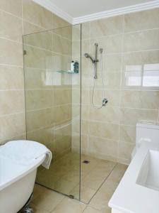 a bathroom with a shower with a toilet and a sink at Family home in Mount Colah +2 photos
