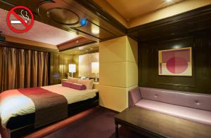 名古屋HOTEL LOVE的一间卧室配有一张床,卧室配有长凳