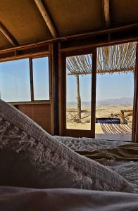 Bett in einem Zimmer mit Blick auf die Wüste in der Unterkunft Wüstenquell Lodge in Usakos