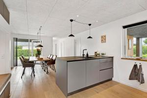 a kitchen and dining room with a sink and a table at Beautiful Holiday Home For 2 Families Near Grenaa Beach in Grenå