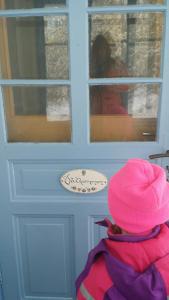 a child wearing a pink hat looking at a door at Stuga Gruvriset in Fredriksberg