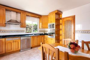 a kitchen with wooden cabinets and a table with a bowl of fruit at Villa Almirante in Badia Gran
