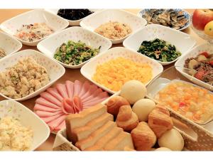 a table filled with different types of food in bowls at Smile Hotel Nara in Nara