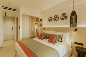 a bedroom with a large white bed with colorful pillows at Opal Paros in Naousa