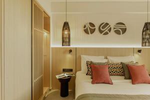 a bedroom with a white bed with colorful pillows at Opal Paros in Naousa