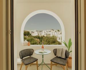 a room with a table and two chairs and a window at Opal Paros in Naousa