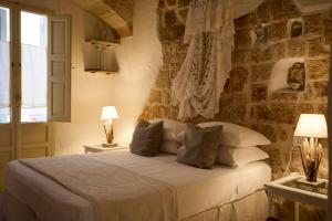 a bedroom with a bed with pillows and a window at Dei Serafini in Polignano a Mare