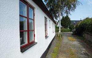 un edificio bianco con due finestre e una strada di 2 Bedroom Amazing Home In Skillinge a Skillinge