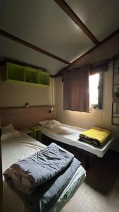 una stanza con due letti e una finestra di chalet 315 camping 4 étoiles Bassin d'Arcachon La Teste a La Teste-de-Buch Altre 9 foto