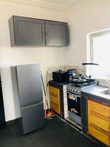 a kitchen with a stove and a sink and a refrigerator at HAVRE DE CHARME A YAOUNDE in Yaoundé +13 photos