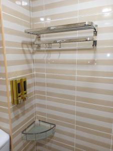 ein Badezimmer mit einem Glasregal an der Wand in der Unterkunft Hotel Seri Intan Tampin in Tampin