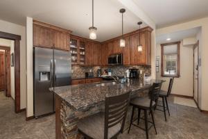 kuchnia z granitowym blatem i drewnianymi szafkami w obiekcie Cozens Pointe E 102 condo w mieście Fraser