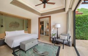a bedroom with a white bed and a chair at Banyan Tree Phuket in Bang Tao Beach