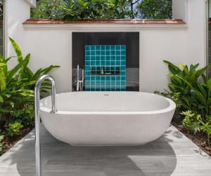 a bath tub in a bathroom with plants at Banyan Tree Phuket in Bang Tao Beach