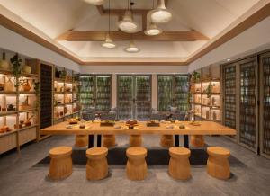 a large dining room with a table and stools at Banyan Tree Phuket in Bang Tao Beach