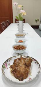 a plate of food on a table with bowls of food at Kaibu Courtyard Superior Apartment, Changjiang Cable Car Nanbin Road, Chongqing in Chongqing