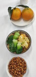 three plates of food with beans and oranges on a table at Kaibu Courtyard Superior Apartment, Changjiang Cable Car Nanbin Road, Chongqing in Chongqing