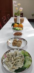 a table with three plates of food on it at Kaibu Courtyard Superior Apartment, Changjiang Cable Car Nanbin Road, Chongqing in Chongqing
