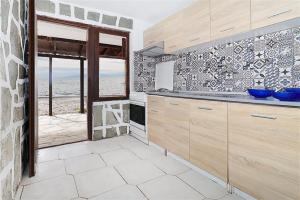 a kitchen with wooden cabinets and a view of the ocean at Ioanna Beach House Fourka 2 bedrooms 5 guests in Skála Foúrkas