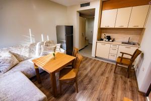 a living room with a table and a kitchen at Hotel Sveti Vasilii Veliki in Gabrovo