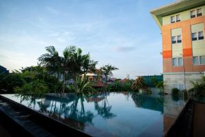 a large swimming pool in front of a building at HARRIS Hotel & Residences Riverview Kuta, Bali in Kuta