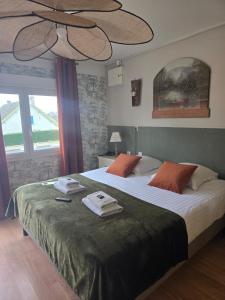 a bedroom with a large bed with towels on it at Hôtel L'ideal le Mountbatten in Arromanches-les-Bains