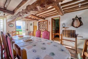 una sala da pranzo con tavolo e alcune sedie di La Ferme de la Chapelle Saint-Roch - Maison de 190 m2 a Isigny-sur-Mer