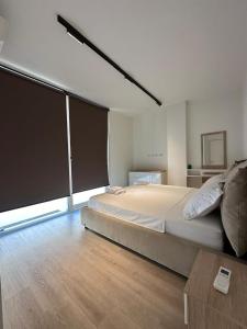 a large bedroom with a large bed and a table at Villa Champagne Green Coast Palase in Palasë