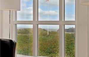una ventana con vistas a un campo a través de ella en Holiday Home Ved Stranden, en Blokhus