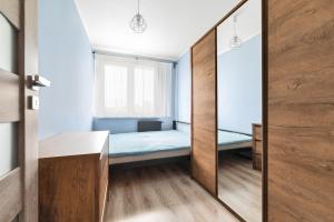 a small bedroom with a bed and a mirror at Simple Nook, Gdańsk Wejhera by Real Apartments in Gdańsk