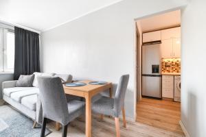 a living room with a table and a couch at Simple Nook, Gdańsk Wejhera by Real Apartments in Gdańsk