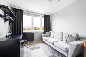 a living room with a white couch and a window at Simple Nook, Gdańsk Wejhera by Real Apartments in Gdańsk
