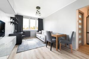 a living room with a couch and a table at Simple Nook, Gdańsk Wejhera by Real Apartments in Gdańsk +5 photos