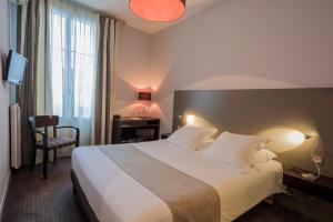 a hotel room with a large bed and a window at Hôtel Ronsard in Tours