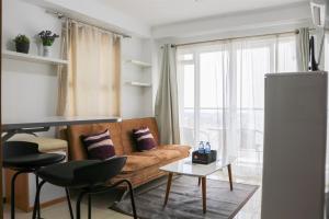 a living room with a couch and a table at Minimalist and Cozy 2BR at Gateway Pasteur Apartment By Travelio in Bandung