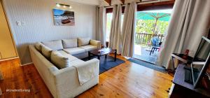 un soggiorno con divano bianco e porta scorrevole in vetro di Milkwood Lodge 2 - Sleeps 8 a Port Edward