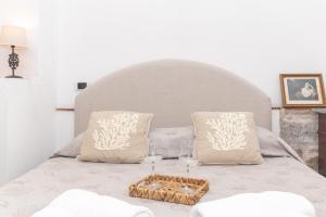 a bed with two pillows and a tray with wine glasses at Le Giare 2 in La Maddalena