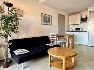 a living room with a couch and a table at Appartement 2 Pièces mezzanine 4 couchages ARGELES SUR MER AR210-015 in Argelès-sur-Mer