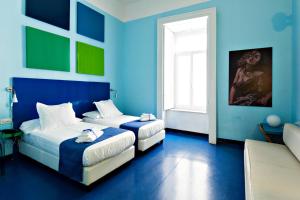 
a bedroom with a blue and white bed and a blue wall at Correra 241 Lifestyle Hotel in Naples
