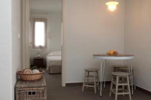 Habitación con mesa, taburetes y cama en Casa Kalypso Suites & Villa, en Steni Vala Alonissos