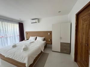 a bedroom with a large bed and a large window at SAWAN Residence Pool Villas in Lamai +42 photos