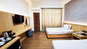 Giường trong phòng chung tại MMUGM Hotel