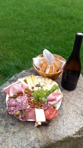 a plate of meat and cheese and a bottle of wine at Alpagas de Barres in Sénaillac-Latronquière