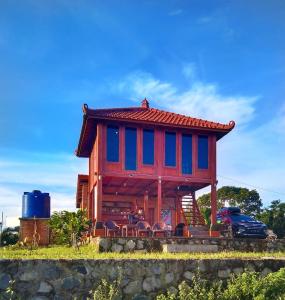 a house with a red and blue roof and chairs at Villa Murah BOEKIT 3G dgn View 3 Gunung & Sunrise in Cikidang