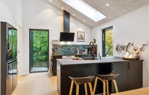 a kitchen with a black island with stools at 3 Bedroom Nice Home In Fårevejle in Fårevejle