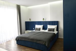 a bedroom with a blue bed with two pillows at Luxury Apartments “Bozdosh” in Uzhhorod